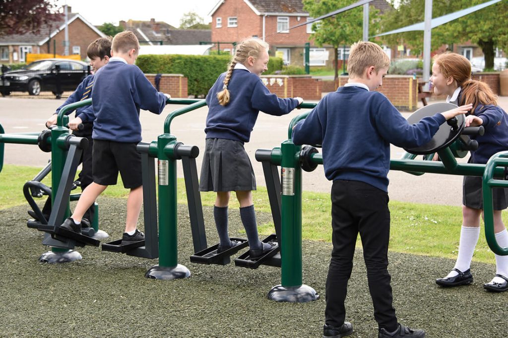 children using an outdoor gym equipment set